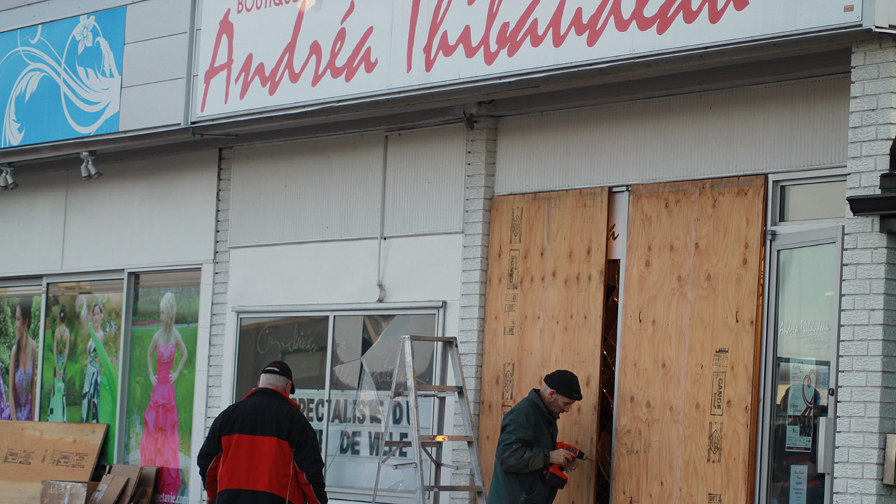 On s'affairait à couvrir les vitrines fracassées tôt ce matin.