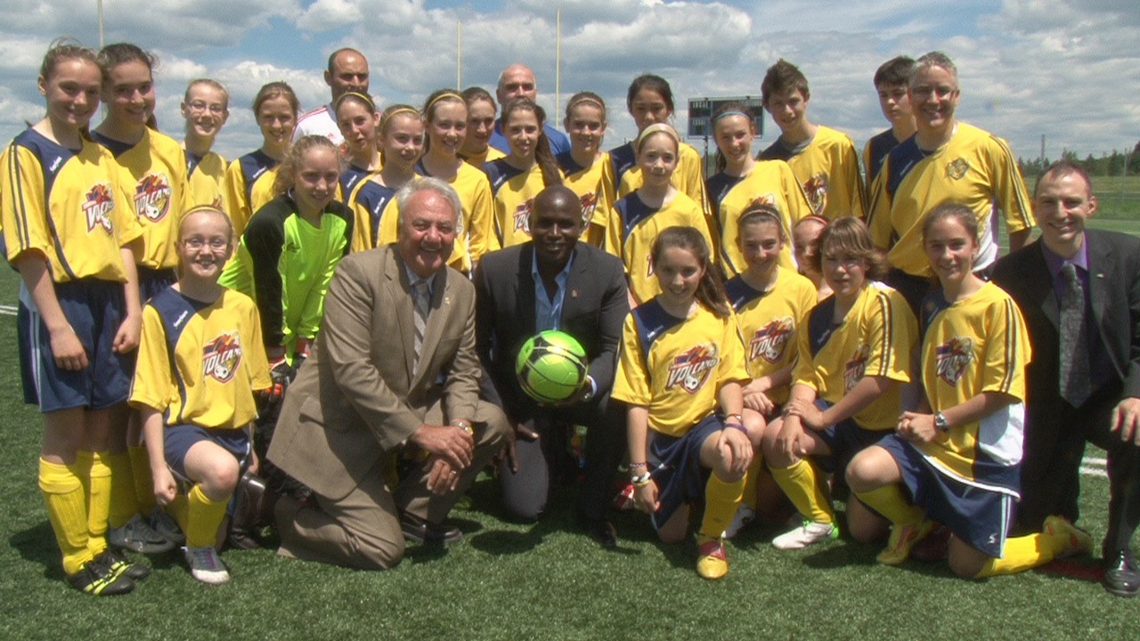 Ali Gerba, en compagnie du maire François Fecteau (gauche), de Marco Gagné du Cégep Beauce-Appalaches (droite), ainsi que de l'équipe de soccer Volcano U13.