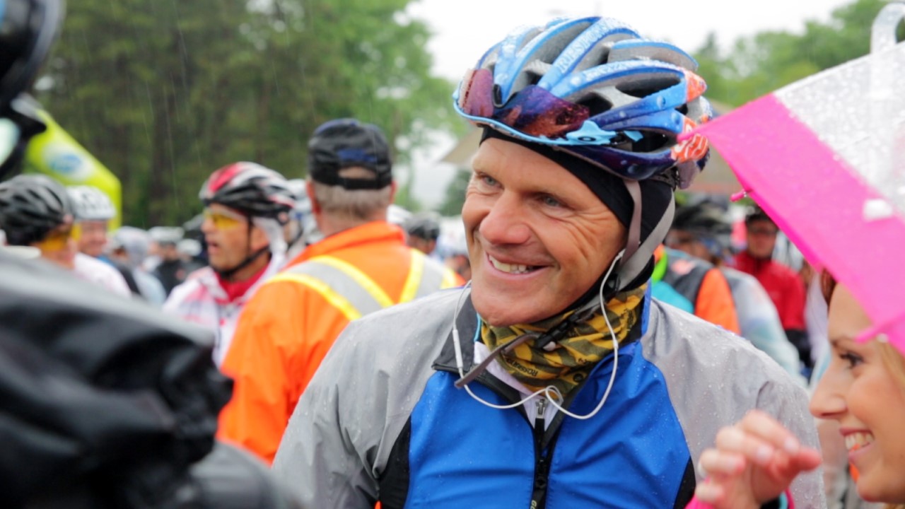 Pierre Lavoie, affichant un grand sourire malgré la température et les kilomètres de vélo parcourus depuis le début du Défi.