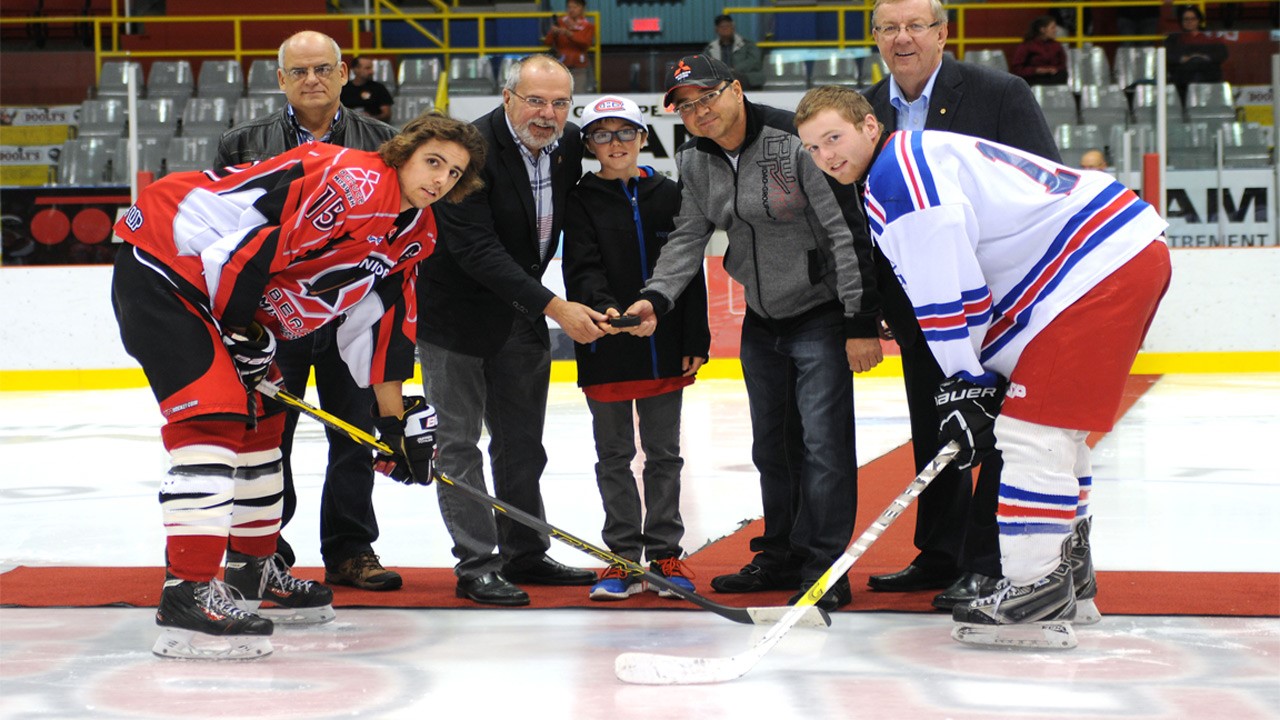 Sur la photo de la mise au jeu protocolaire on retrouve dans l’ordre habituel, Alain Bédard président du Club de hockey Junior Beauce-Sud, Claude Morin maire de Ville St-Georges, Pierre Lessard président de Beauce Mitsubishi, et Marc Couture directeur général, de la Caisse du Sud de la Beauce représentant aussi La Caisse du Sud de la Chaudière. Les joueurs en présence pour la mise au jeu sont les capitaines, en chandail rouge Jacob Côté du Beauce Mitsubishi de Beauce-Sud, et en chandail blanc Mathieu Poulin du Bar l’Entracte de Beauce-Centre.