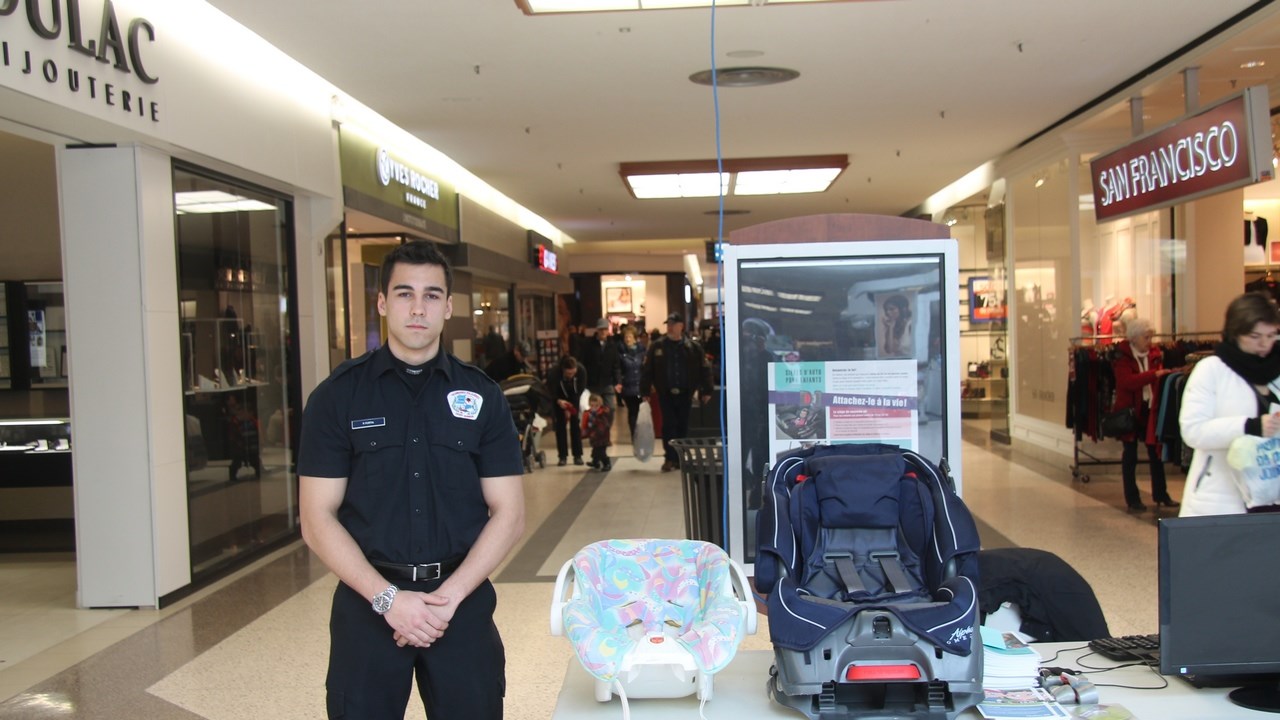 Patrick Fortin, étudiant en techniques policières au Cégep Garneau, tenait un kiosque au Carrefour Saint-Georges sur les normes de sécurité des sièges d'auto pour enfants.  