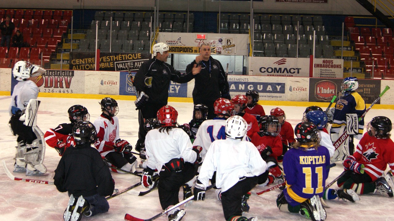 Steve Gosselin et Raymond Delarosbil avec plusieurs jeunes hockeyeurs