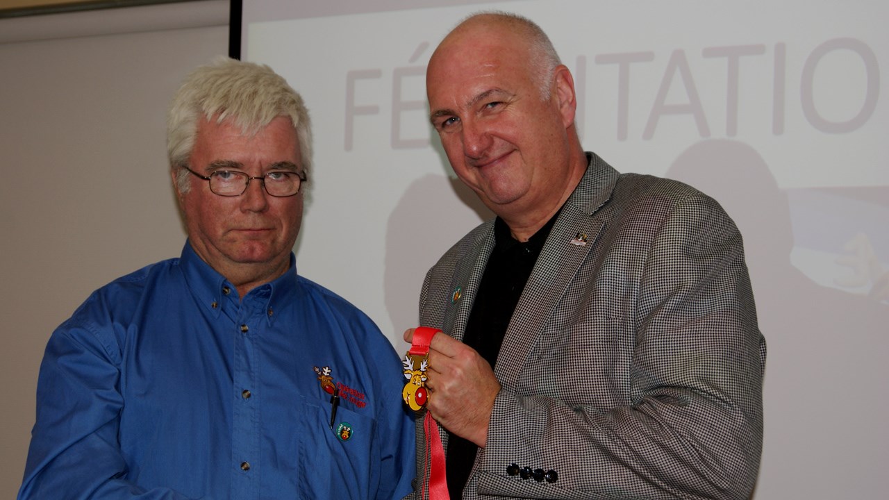 Le président d'honneur d'Opération Nez rouge, Normand Lessard (à droite), reçoit une médaille pour souligner son implication au sein de l'organisme.