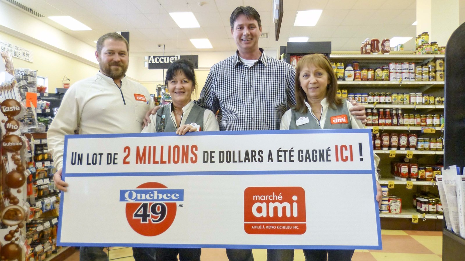 De gauche à droite, le gérant du Marché Ami, une employée, le gagnant du gros lot et une employée du magasin.