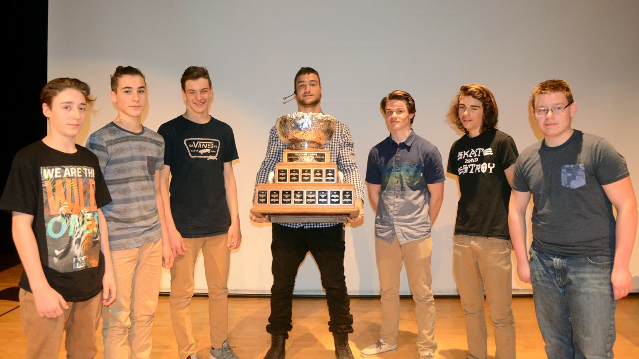 Adam Auclair tient la coupe Vanier en compagnie de quelques footballeurs de la polyvalente Saint-François.
