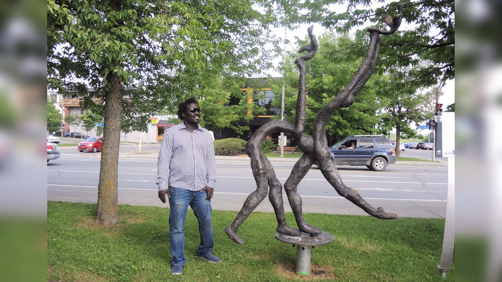 Le sculpteur burkinabé Yacouba Toure, originaire de Ouagadougou, au Burkina Faso, présentant son son oeuvre « Dansons dans un monde de paix » à Saint-Georges.
