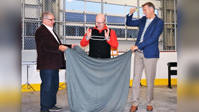 Alain Larivière, président de la Caisse Desjardins du Sud de la Beauce et Maxime Bernier, député fédéral de Beauce, se prêtent au jeu de Marcus le magicien lors de l'inauguration du nouveau stade de Saint-Zacharie.