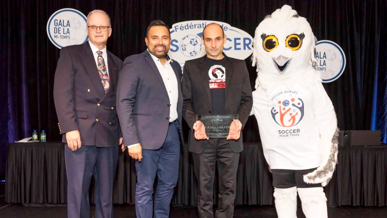 Alfred Picariello en compagnie des responsables de la Fédération de soccer du Québec et de la mascotte Koufran, mascotte officielle du soccer québécois, lors de la remise du titre.
