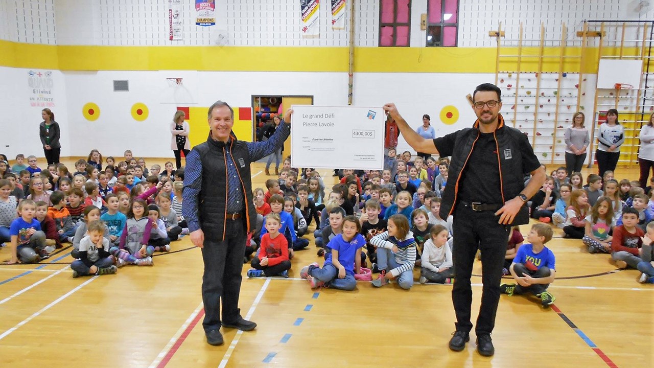 Pierre Vachon (à gauche) et Claude Quirion (à droite) ont remis un montant de 4 300 $ à l'école primaire Les Sitelles de Saint-Georges, qui servira à financer un futur terrain de soccer synthétique.