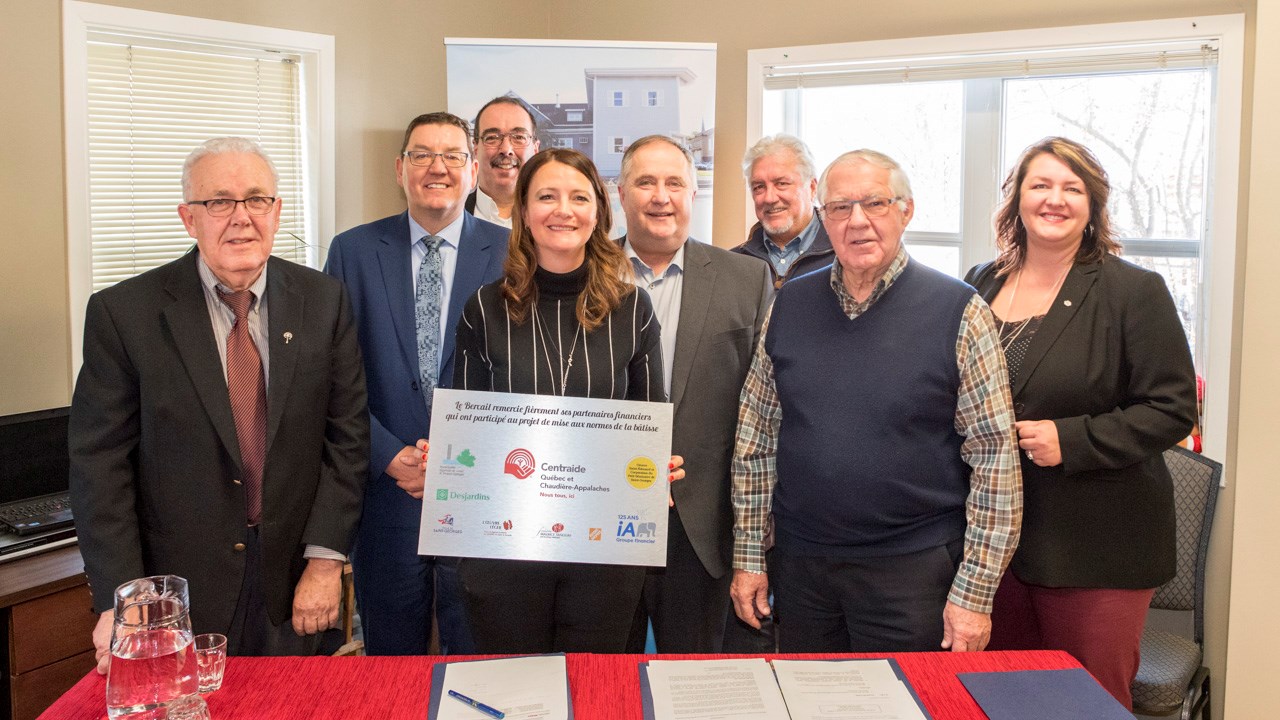 Au centre, tenant la plaque commémorative, la directrice générale du Bercail, Cathy Fecteau, est entourée des différents partenaires du projet.