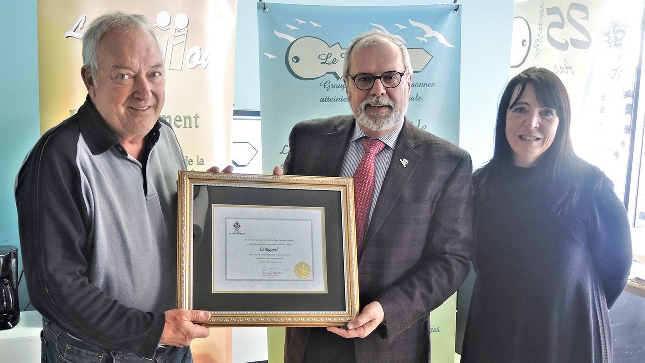 Claude Morin, maire de la Ville de Saint-Georges, au centre, remet un certificat de reconnaissance à l'organisme Le Rappel, de Saint-Georges, pour souligner ses 25 années d'activité. À droite, Annie Bellavance, coordonnatrice du Service de développement et de maintien en emploi du Rappel.