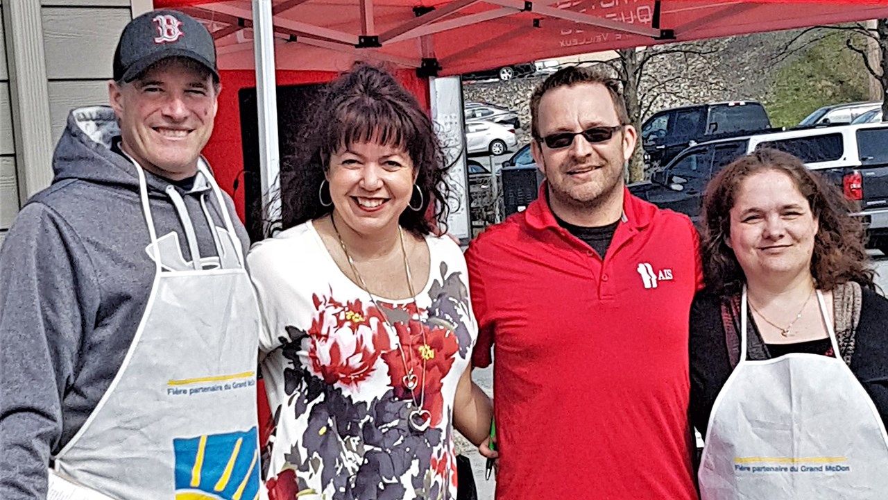 Emmanuel Rodrigue, directeur général de l'Association pour l'intégration sociale Beauce-Sartigan en rouge, au centre, accompagné de bénévoles du Grand McDon au McDonald's situé sur le boulevard Lacroix, à Saint-Georges.