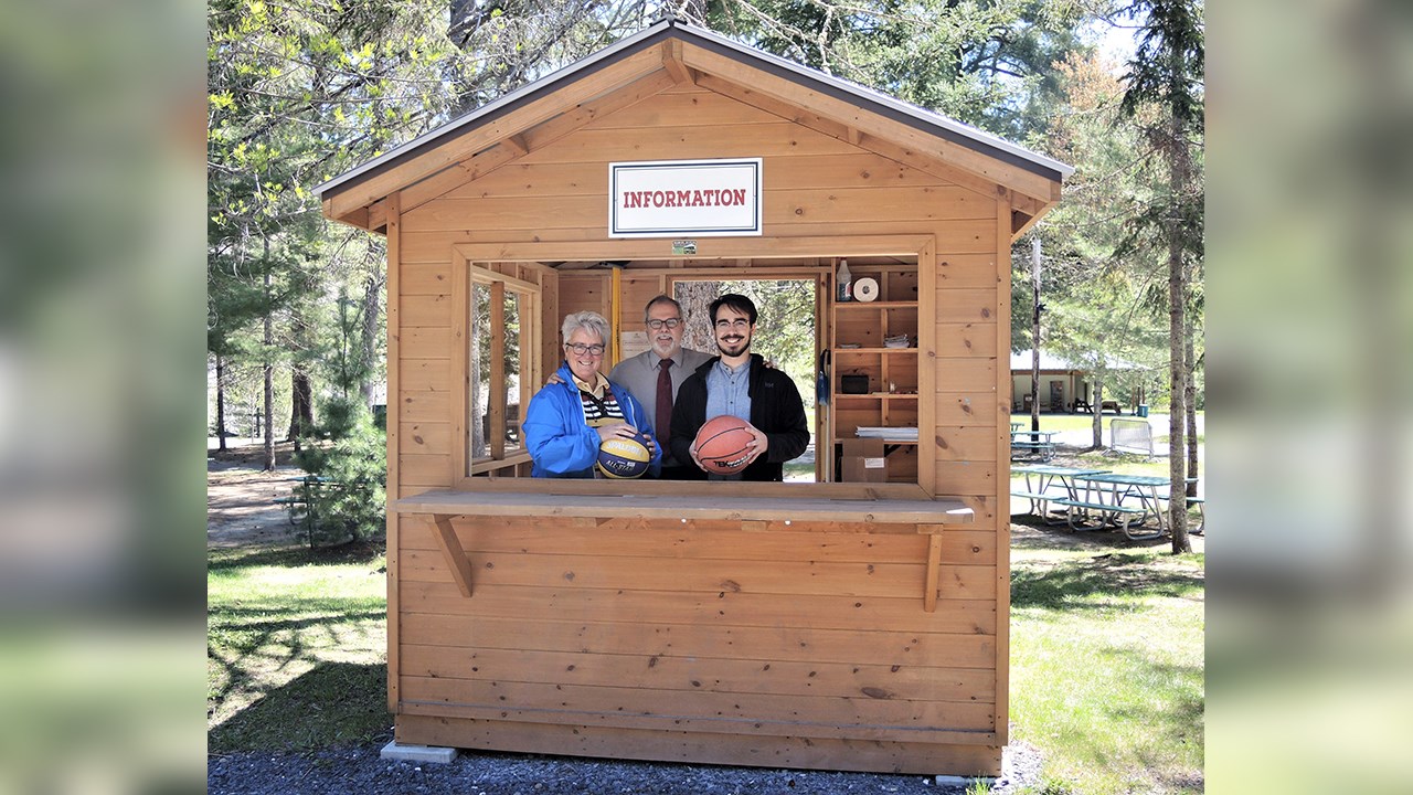 De gauche à droite : Dans le kiosque d'informations et de prêt de matériel se trouvent Carole Paquet, directrice du Service des loisirs et de la culture de la Ville de Saint-Georges, Claude Morin, maire de la Ville de Saint-Georges, et Samuel Duval, stagiaire au Service des loisirs et de la culture de la Ville de Saint-Georges, lors de la conférence de presse annonçant la programmation estivale 2018 au parc des Sept-Chutes de Saint-Georges, jeudi le 24 mai 2018.