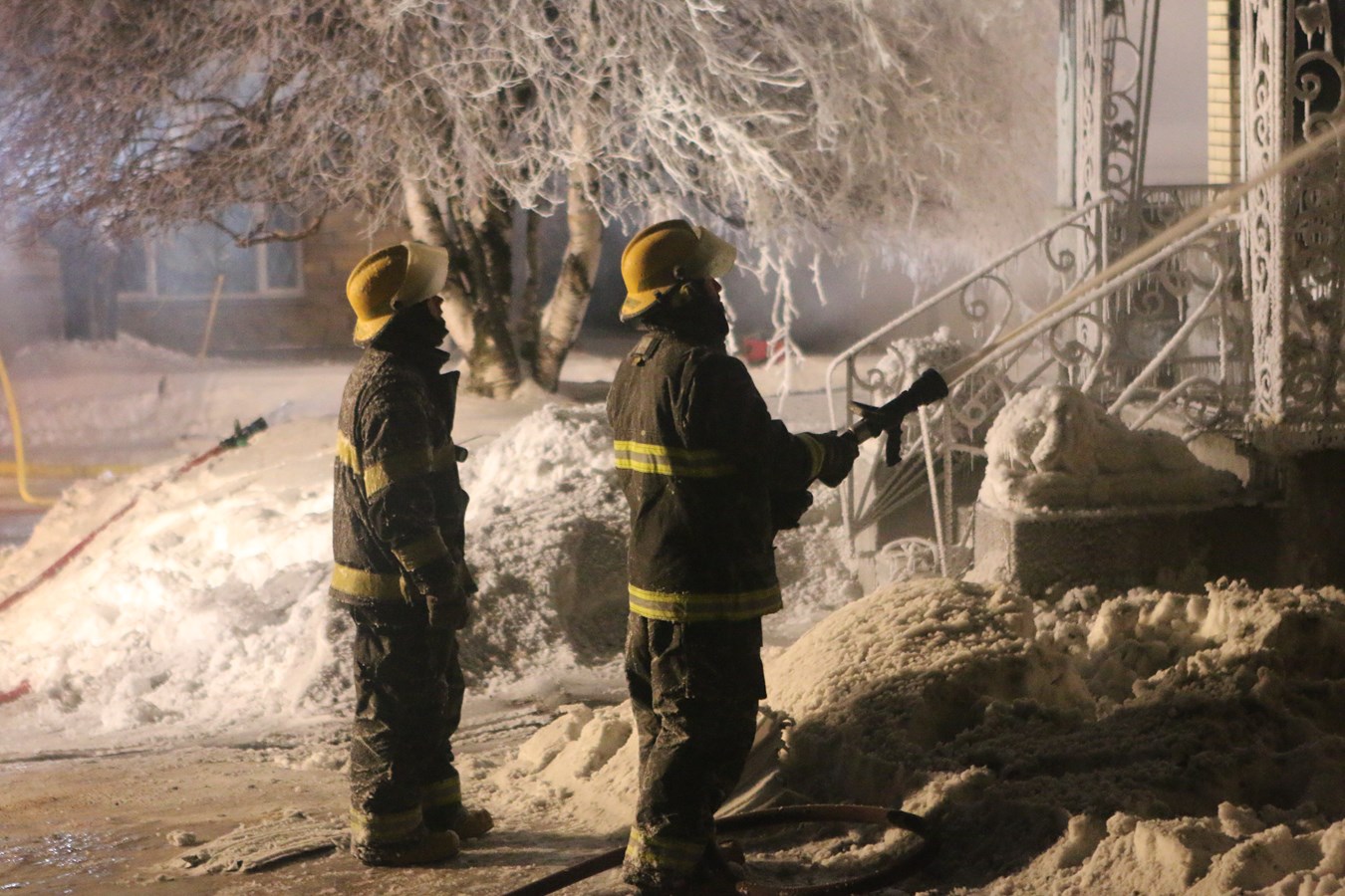 Deux pompiers arrosent l'intérieur d'une résidence à Sainte-Clotilde suite à un incendie