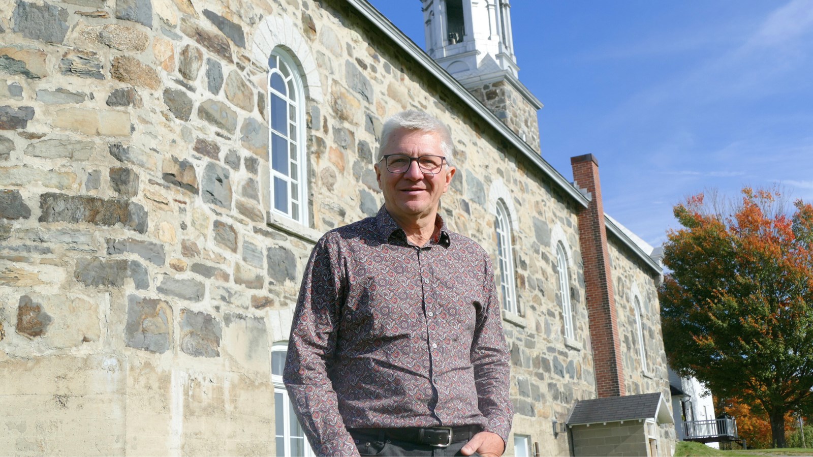 Le président de Cultiver pour partager, Jean Champagne, devant l'église de Saint-Alfred.