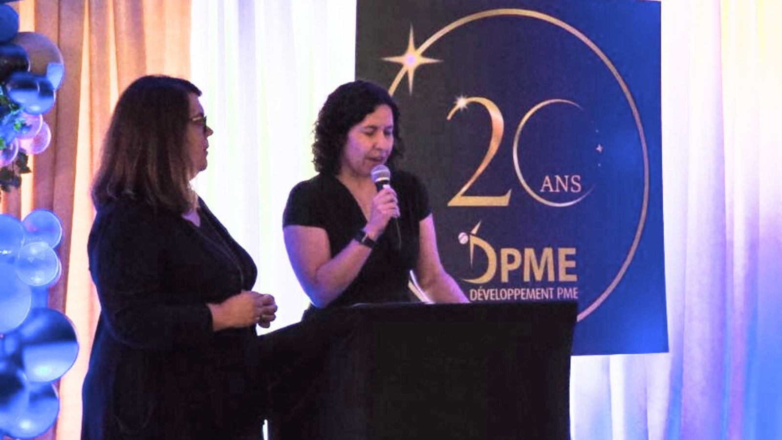 La présidente du conseil d’administration de DPME, Dominique Nadeau, s'adressant aux participants de l'assemblée, en compagnie de la directrice générale de l'organisme, Marie-Pierre Poulin.