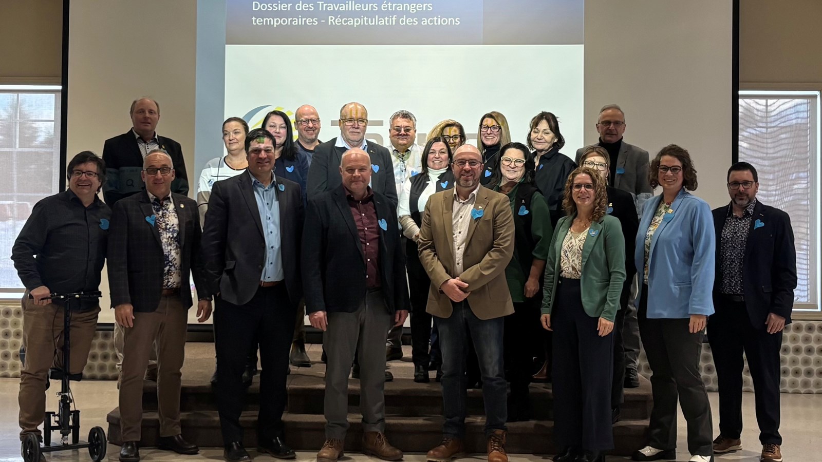 De gauche à droite : 1re rangée (avant) M. Rick Lavergne, directeur général de la MRC des Appalaches, M. Patrice Mathieu, préfet de la MRC Beauce‑Centre, M. Marc‑Alexandre Brousseau, maire de Thetford Mines et président de la Commission sur l’immigration de l’UMQ, M. Christian Chabot, préfet de la MRC des Etchemins, M. Daniel Turcotte, président de la TREMCA et préfet de la MRC de Lotbinière, Mme Manon Bougie, mairesse de la Ville de Saint‑Georges, Mme Gabrielle Brisebois, mairesse de la Ville de Montmagny M. François Bélanger, préfet de la MRC Beauce‑Sartigan
2e rangée (rangée intermédiaire) : Mme Nancy Labrecque, directrice générale de la Ville de Montmagny, M. Normand Caron, préfet de la MRC de L’Islet, Mme Judith Leblond, directrice générale de la MRC des Etchemins, Mme Luce Lacroix, mairesse de la Ville de Sainte‑Marie, Mme Anne‑Julie Poirier, représentante de la direction générale à la Ville de Lévis
3e rangée (rangée arrière) : M. Patrick Mathieu, maire de Beauceville, Mme Mélanie Sicotte, conseillère municipale, Ville de Lévis, M. Stéphane Bergeron, directeur général de la MRC de Lotbinière, M. Éric Paquet, directeur général de la MRC Beauce‑Sartigan, Mme Nancy Labbé, directrice générale de la MRC de la Nouvelle‑Beauce, Mme Anick Beaudoin, directrice générale de la MRC de Bellechasse, Mme Marcelle Paradis, directrice générale adjointe de la MRC Beauce‑Centre et M. Luc Dion, préfet de la MRC de Bellechasse