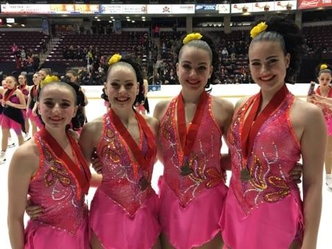 Quatre patineuses du club de patinage artistique Les Étoiles d'Argent avec l'équipe Rythmiks