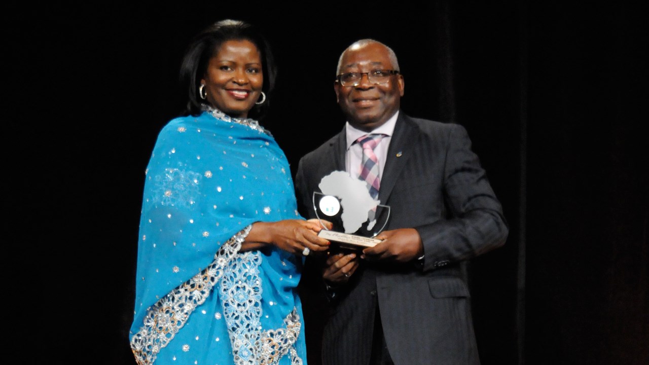 Le coordonnateur du Service de la coopération et du développement international, Philippe Mpeck, reçoit le prix remis par Amina Gerba, vice-présidente d’Afrique Expansion.