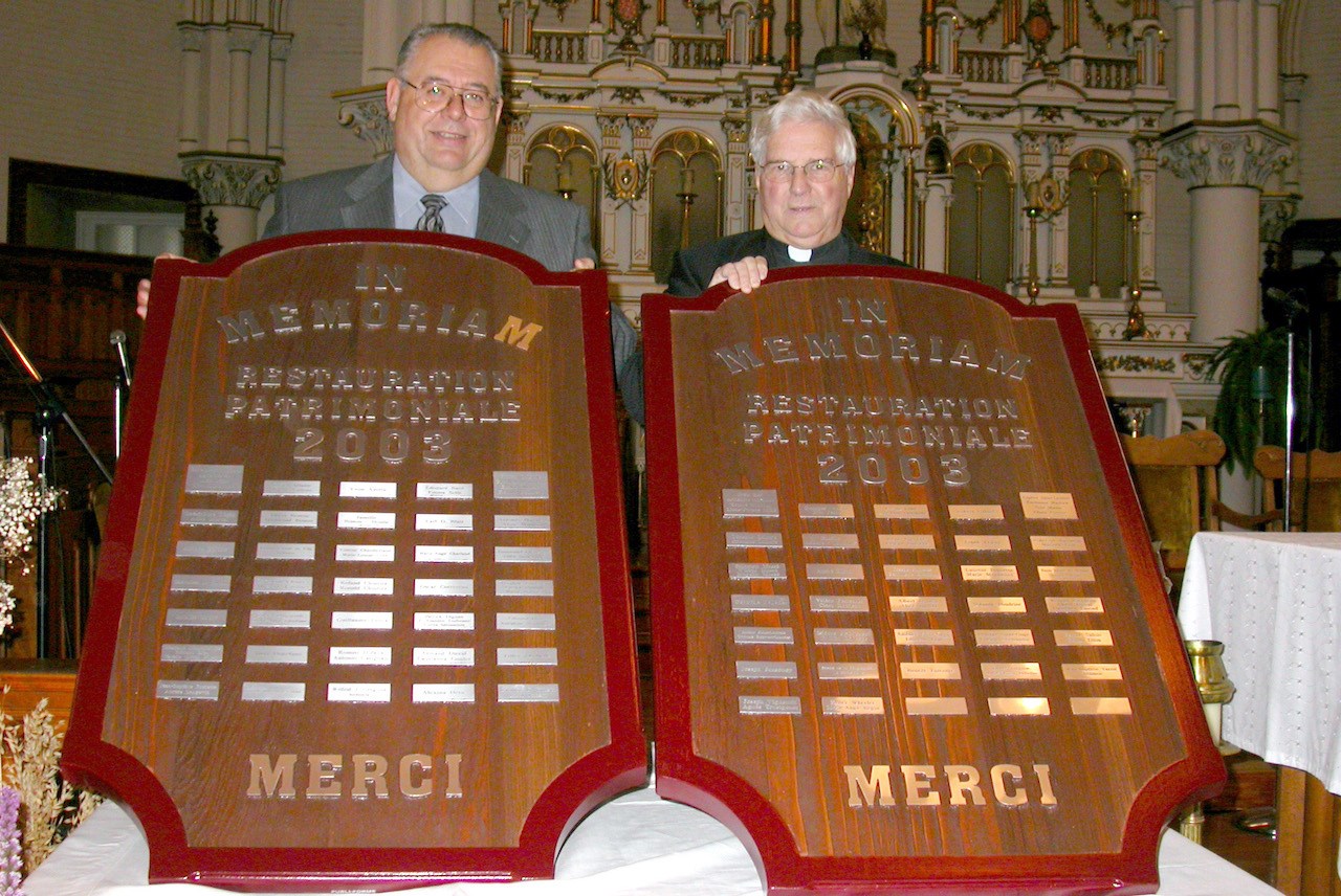 Novembre 2003. Les deux présidents du comité de financement pour la première phase de rénovation de l’ancienne église Saint-Philippe, Malcolm Wheeler et Mgr Georges Cloutier, présentent les plaques In Memoriam réservées à des donateurs.
