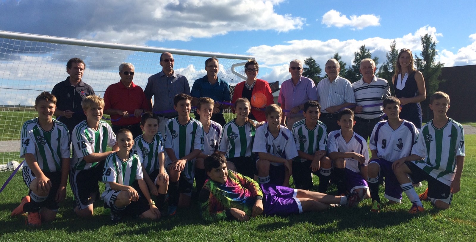 Une photo de l’inauguration du terrain sur laquelle apparaissent les maires de la région de Richmond, des responsables de l’école régionale et des joueurs et joueuses de soccer.