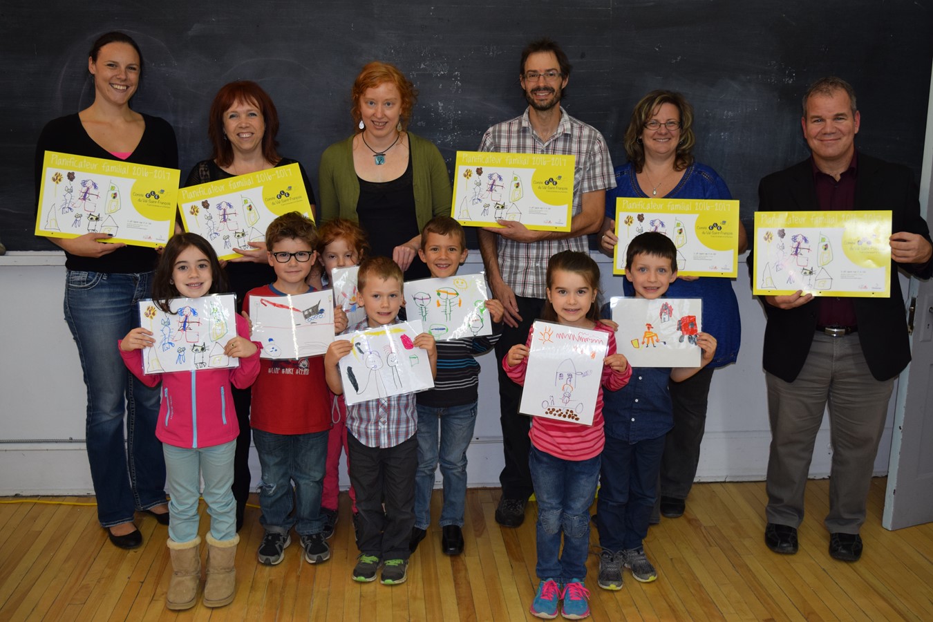 Des jeunes gagnants du concours de dessins sur le thème de la lecture. Ils sont accompagnés de membres du comité ÉLÉ, partenaires et Serge Dion, directeur général adjoint et directeur du Service des ressources éducatives à la Commission scolaire des Sommets.