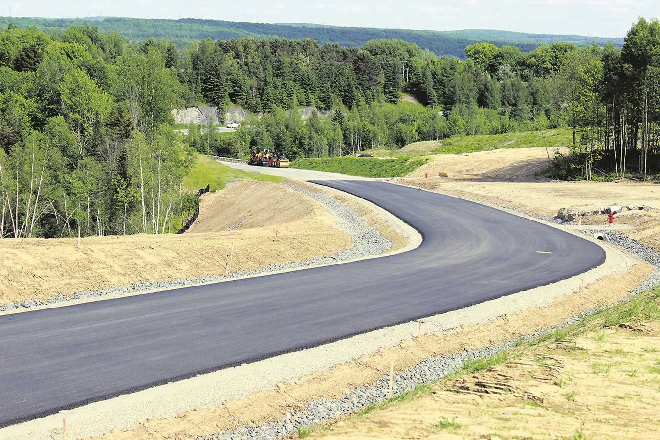 Une vue englobant les deux étapes d’asphaltage, les bornes fontaines à partir de la rue Maurice-Bachand où se profile la 249.