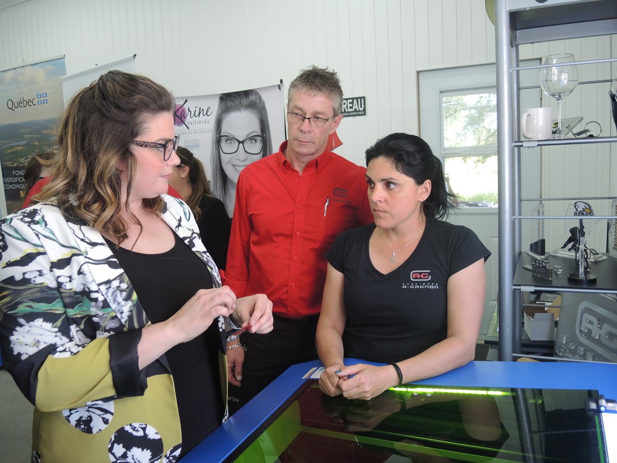 Karine Vallières se fait expliquer le fonctionnement du graveur laser par les employés de Enseignes A. Gagnon.