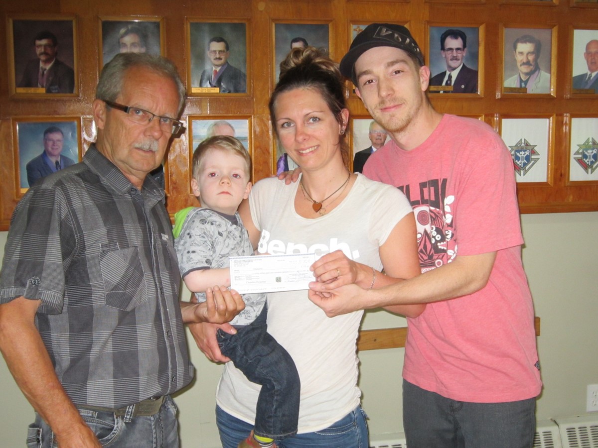 Le Grand Chevalier Marcel Couture a remis le chèque à Annie Blais et Rémi Daigle, les parents de Jacob.