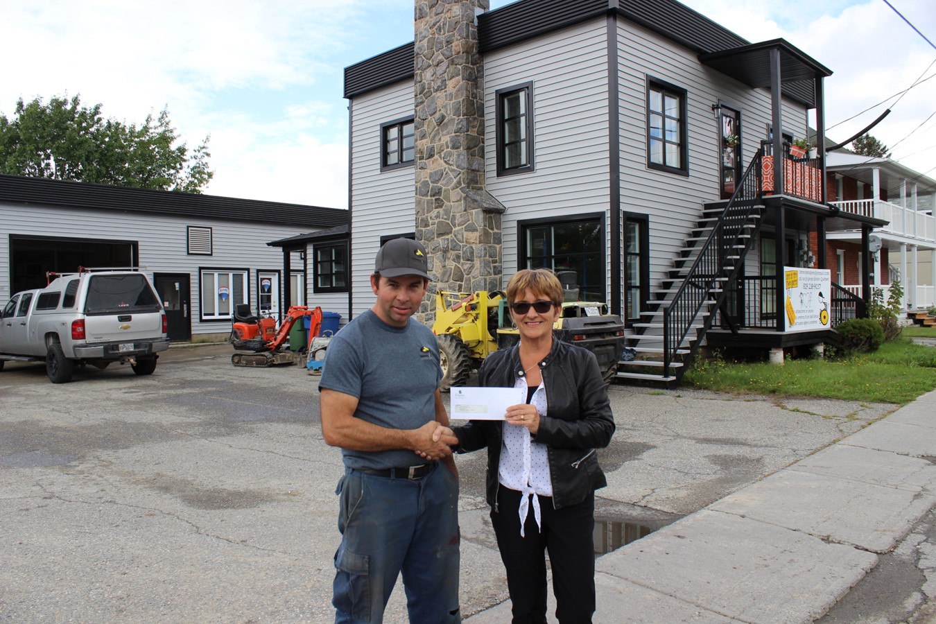 La rénovation extérieure englobant chacun des bâtiments a permis à Dominic Fredette d’obtenir un encouragement monétaire de la Ville pour l’ensemble de sa façade. Il reçoit sur cette photo le montant de 10 000 $ des mains de Mme Bureau.