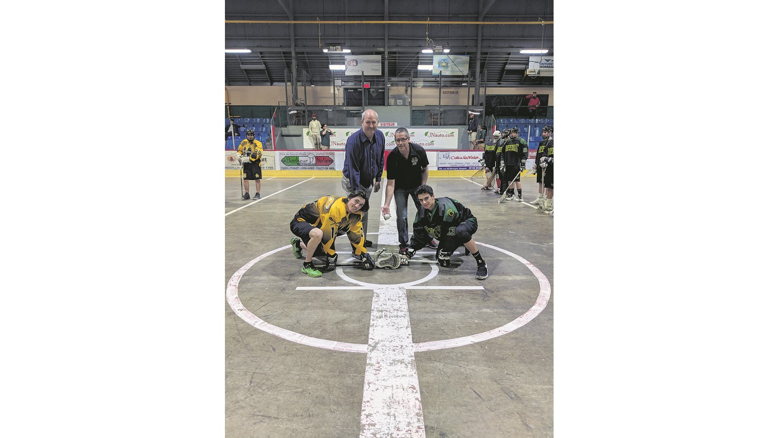 La mise au jeu protocolaire entre le capitaine estrien, Charles Thibodeau, et celui des Griffins de Gloucester, Nic Ayoub, en présence de deux dirigeants des Aigles Extrêmes, Ghislain Roy et Marc-André Turgeon.