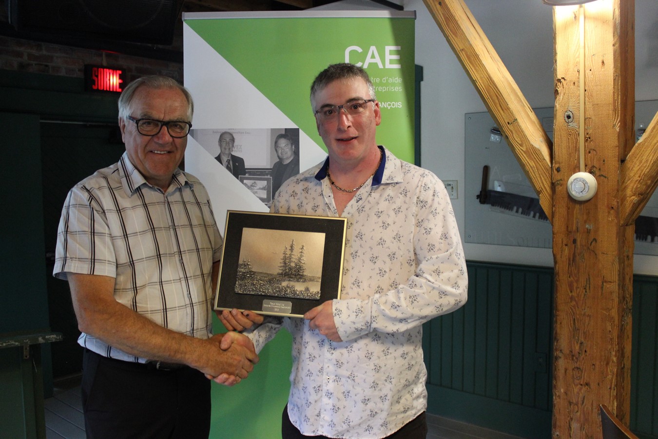 André Desmarais remettant une plaque souvenir à Pascal Vallée.