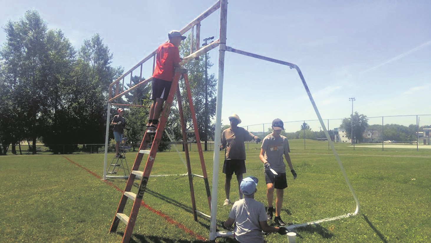 Plusieurs personnes ont remis le terrain du Tournesol en parfait état, dont ces bénévoles occupés à rafraichir les poteaux des filets. (Crédit photo : l’Association du soccer mineur de Windsor)