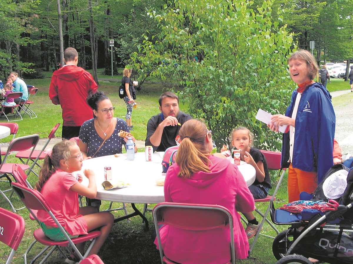 Colombe Landry (debout, à droite) en présence de familles à l’occasion d’un cadre champêtre.
