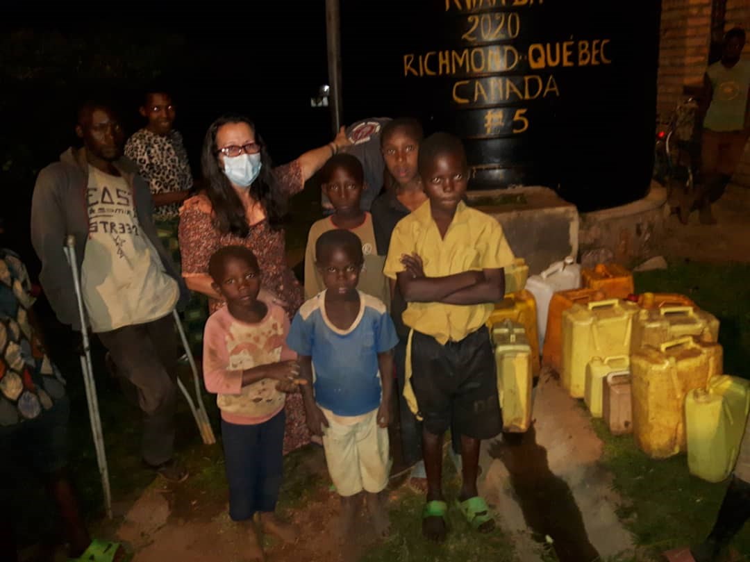 Carole Saint-Hilaire, de l’organisme Un Brin d’Espoir-Rwanda, en compagnie d’enfants allant chercher de l’eau à la citerne.