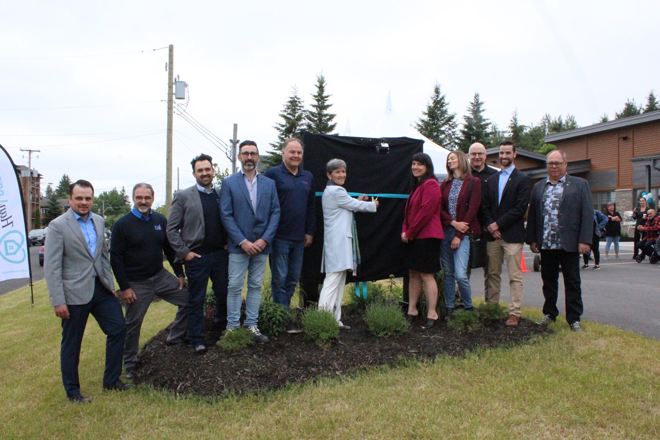 Les personnes présentes à l’inauguration ont pris part à la traditionnelle coupe de ruban. On reconnaît Shawn Boissonneault, Denis Dion, Martin Dion, François Poirier (donateurs, location Windsor) ; Gaétan Pélissier (donateur privé) ; Sylvie Bureau (donateur, mairesse de Windsor), Anik Roy Trudel (cheffe de direction et présidente de Han Logement) ; Marie-Noëlle Foschini (conseillère, immobilier social, communautaire et abordable, Fonds immobilier de Solidarité FTQ) ; Richard Lessard (donateur, Masonite) ; Marc-Antoine Laplante, Marc Marin (donateurs, Caisse Desjardins du Val Saint-François).