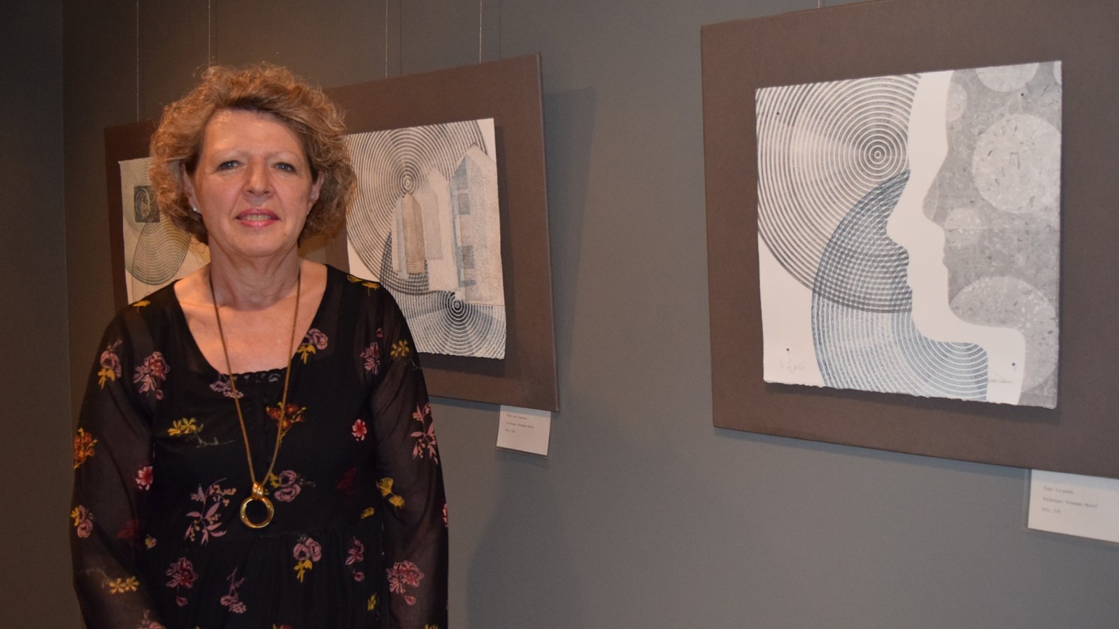 Mme Carmen Dubuc photographiée auprès de certaines de ses œuvres.
