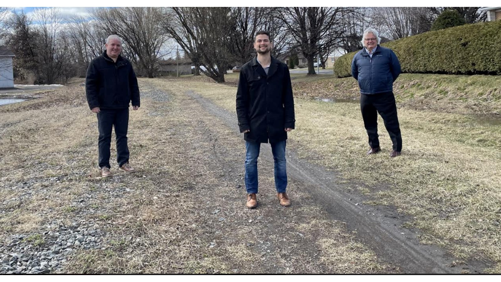 Les conseillers Patrick Rancourt et Jacques Smith prennent la pose avec le maire Miguel Lemieux sur l'ancienne emprise ferroviaire, là où sera construit le sentier polyvalent