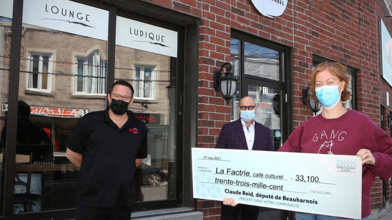 Éric Rochette, président de La Factrie, café culturel, Claude Reid, député de Beauharnois, Émilie Fortier, directrice générale de La Factrie, café culturel prennent la pose lors de la remise de la subvention à l'organisme sis rue du Marché 

