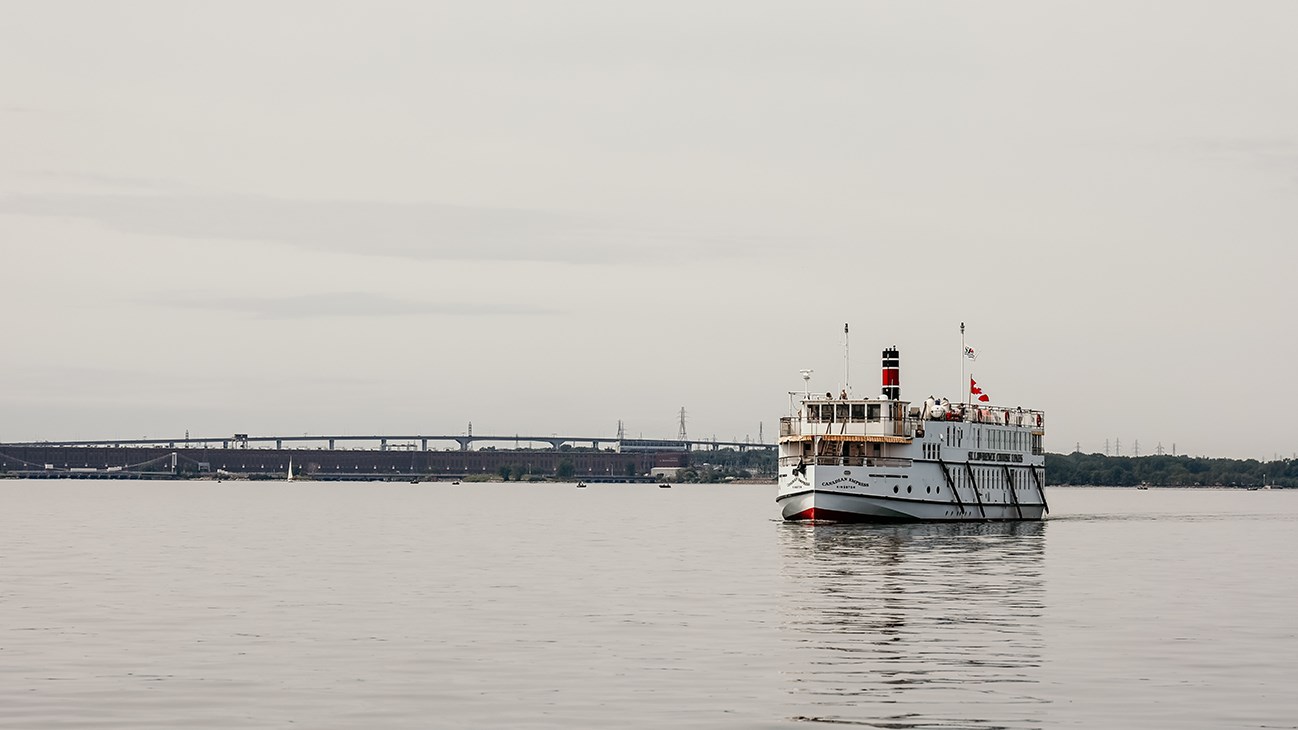 Croisière sur le lac Saint-Louis avec une toile de fond le barrage de Beauharnois et le pont de l'autoroute 30.