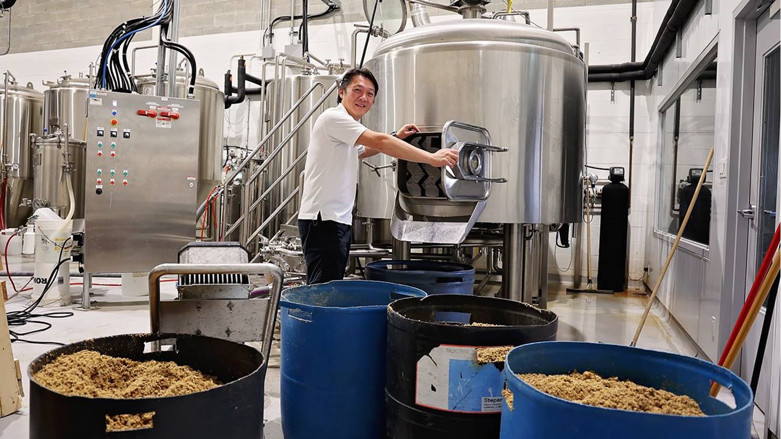 Michel Chen, copropriétaire de la Microbrasserie Trois Lacs prend la pose devant les rejets de drêche qui seront réutilisés par deux entreprises de la région
