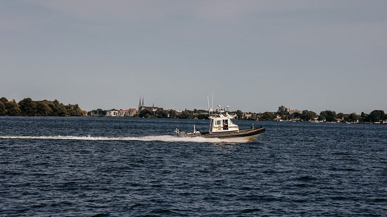 Patrouille nautique de la Sûreté du Québec sur le lac Saint-François avec Salaberry-de-Valleyfield en toile de fond.