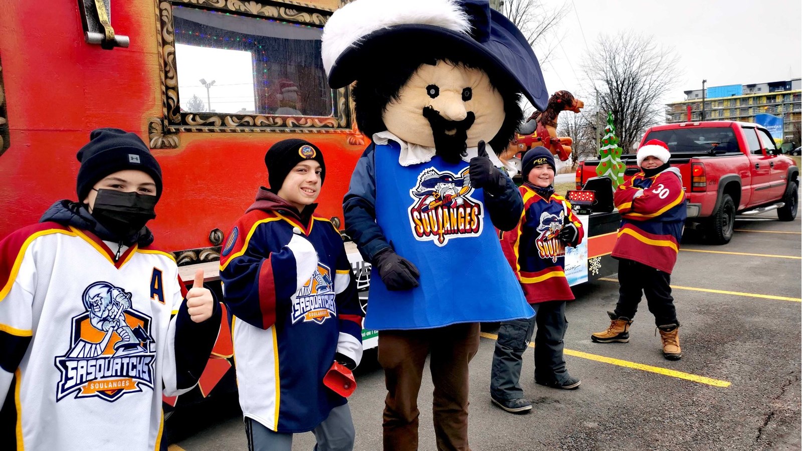 Des joueurs de l'équipe des Sasquatchs de Soulanges participent aussi à la parade aux côtés de la mascotte de la formation sportive