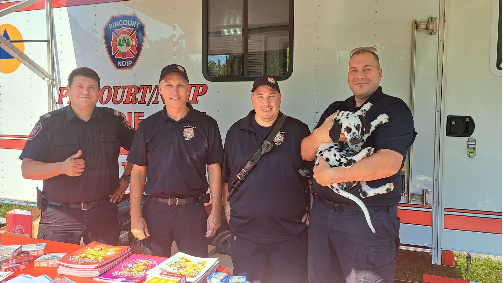 Des représentants des brigades incendies de Pincourt et Notre-Dame-de-l'île-Perrot étaient sur place pour assurer la sécurité des festivaliers. Ils prennent la pose avec la mascotte Penny