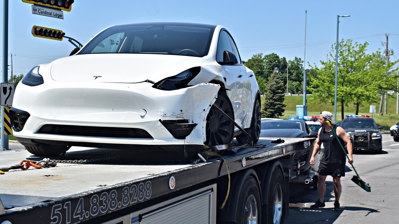 A damaged vehicle involved in a two-car accident is loaded onto a flatbed tow truck at the intersection of Rue Duhamel and Boulevard Cardinal-Léger on May 28.