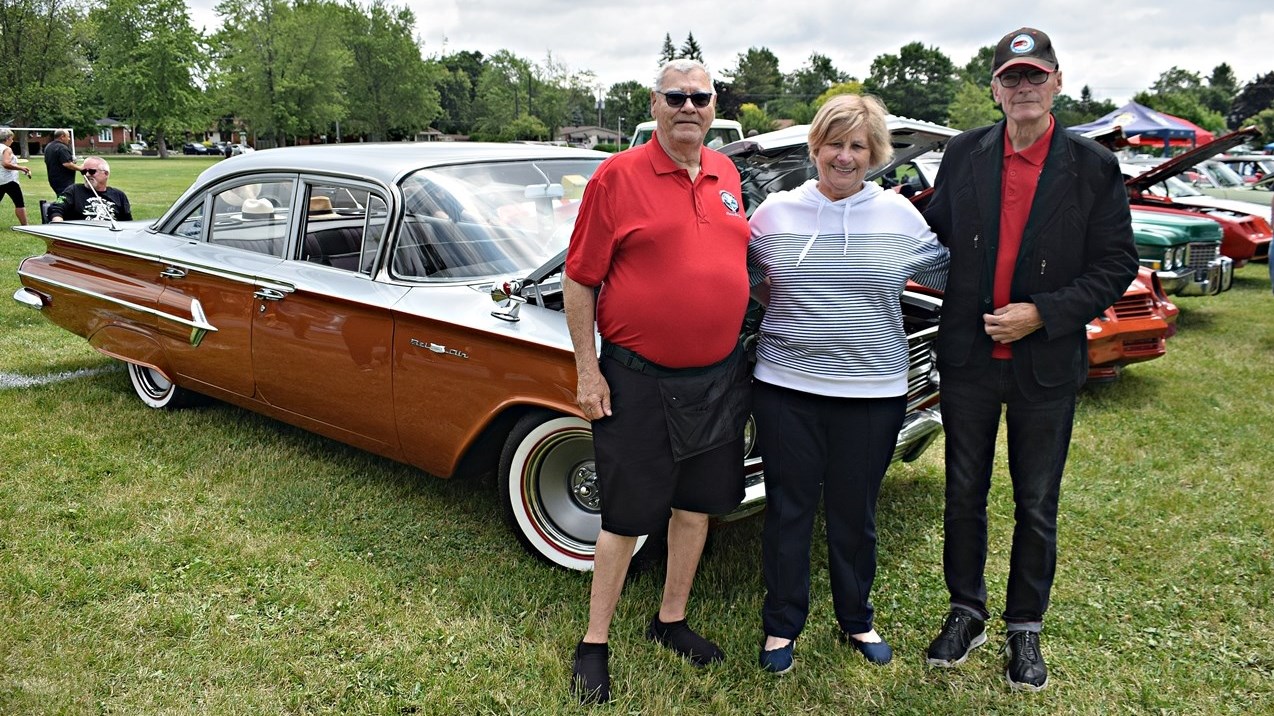 Pierre Saint-Jean (left), Huguette Senécal, and Jean-Yves Gauthier from Voitures anciennes du Québec stand in front of an old car at the first antique car show in Bellevue Park in Pincourt, on June 18.