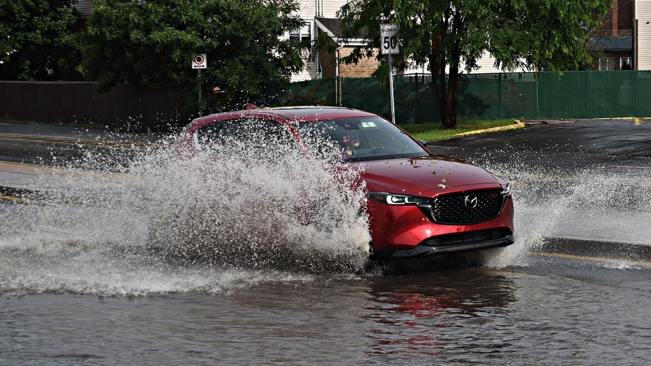 A car drives through flood waters on Boulevard de la Gare in Vaudreuil-Dorion on June 26.
