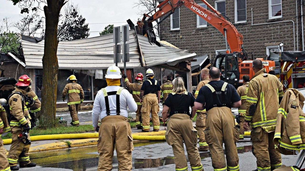 Firefighters watch as Séguin Sport in Rigaus is demolished after an early morning fire in Rigaud.