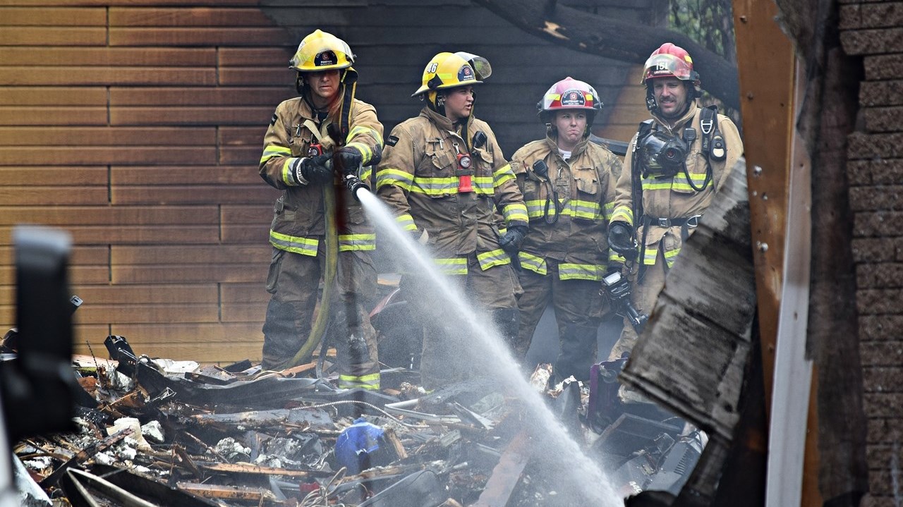 Firefighters clean up after a fire destroyed Séguin Sport in Rigaud this morning.