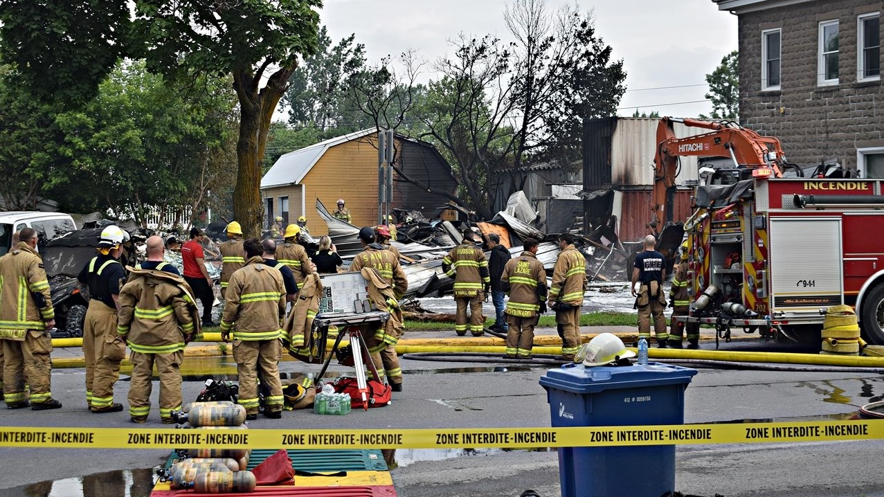 Firefighters clean up after a fire destroyed Séguin Sport and was demolished this morning in Rigaud.